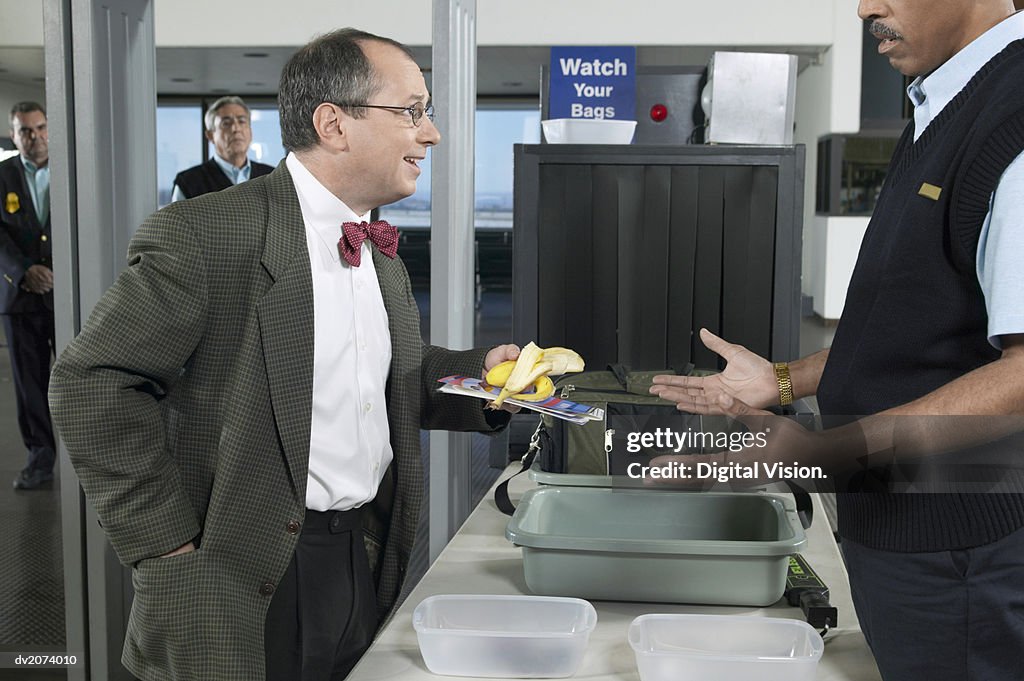 Man Removing a Banana Peel at Airport Customs