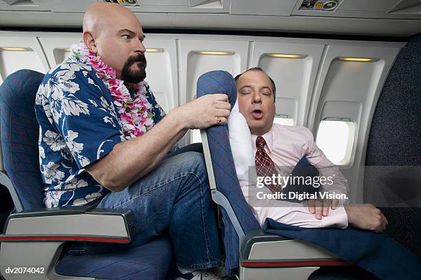 passenger angry about the lack of seating space on an aeroplane - enge stock-fotos und bilder