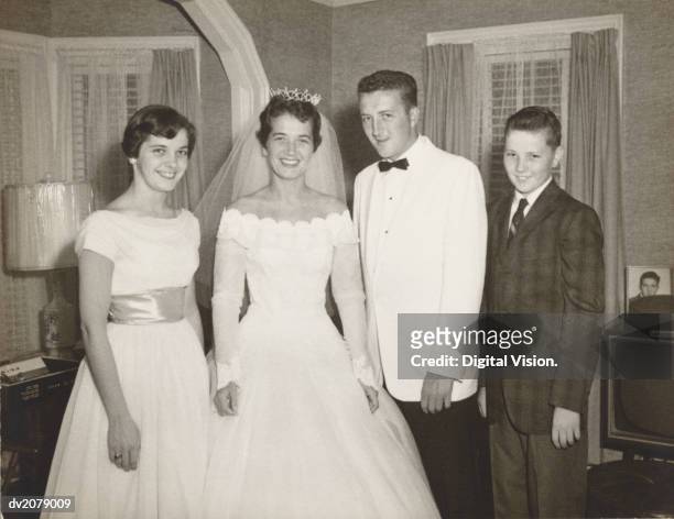 1950s portrait of a bride and groom with their bridesmaid and page boy - pageboy stockfoto's en -beelden