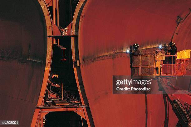 workers welding a ship's hull - construtor de navios imagens e fotografias de stock