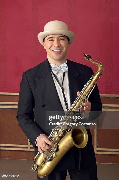 portrait of a male saxophonist in a suit and a porkpie hat - greggory stock-fotos und bilder