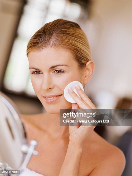 woman cleansing her face with a cotton wool pad - wattepad stock-fotos und bilder