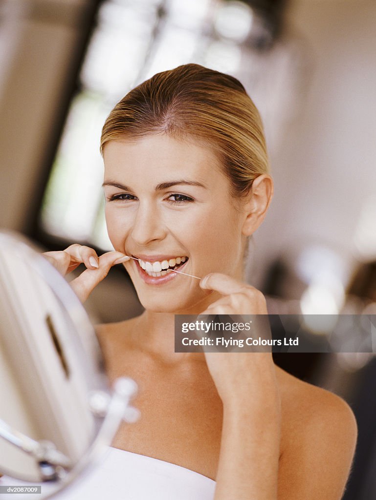 Woman Flossing Her Teeth