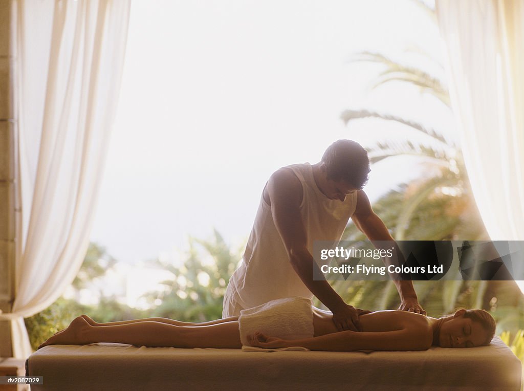 Woman Having her Back Massaged as she Lies on a Treatment Table