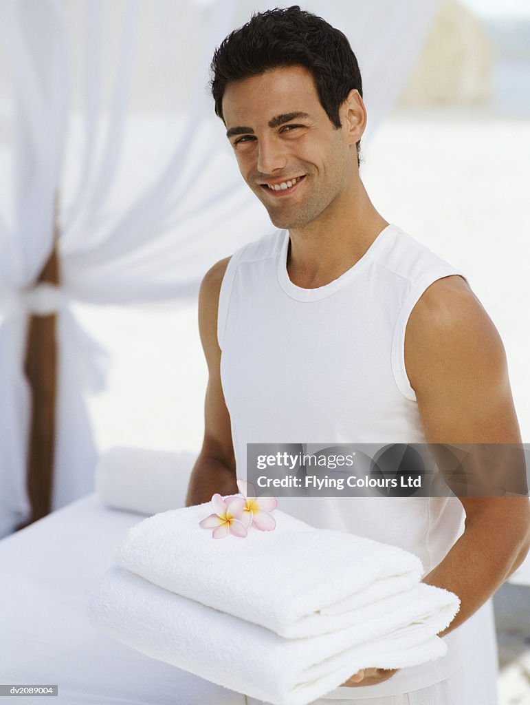 Portrait of a Male Attendant Carrying Folded Towels