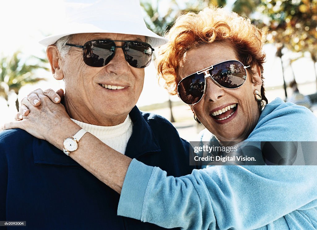 Outdoor Portrait of a Happy Senior Couple Wearing Sunglasses