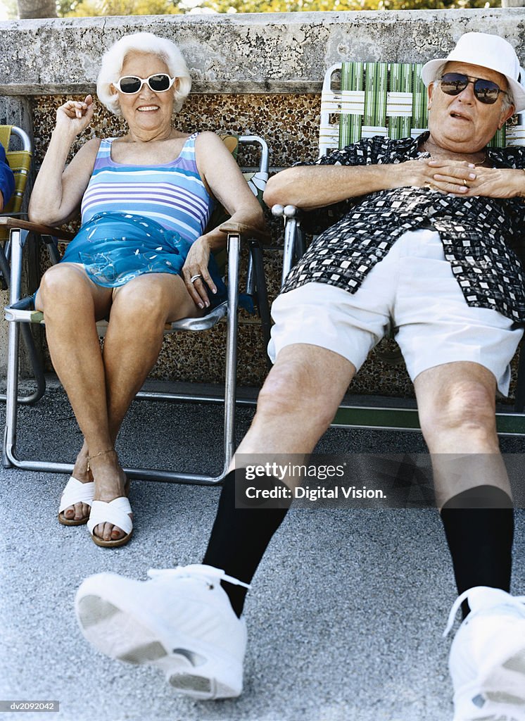 Senior Couple Sit on Chairs Sunbathing