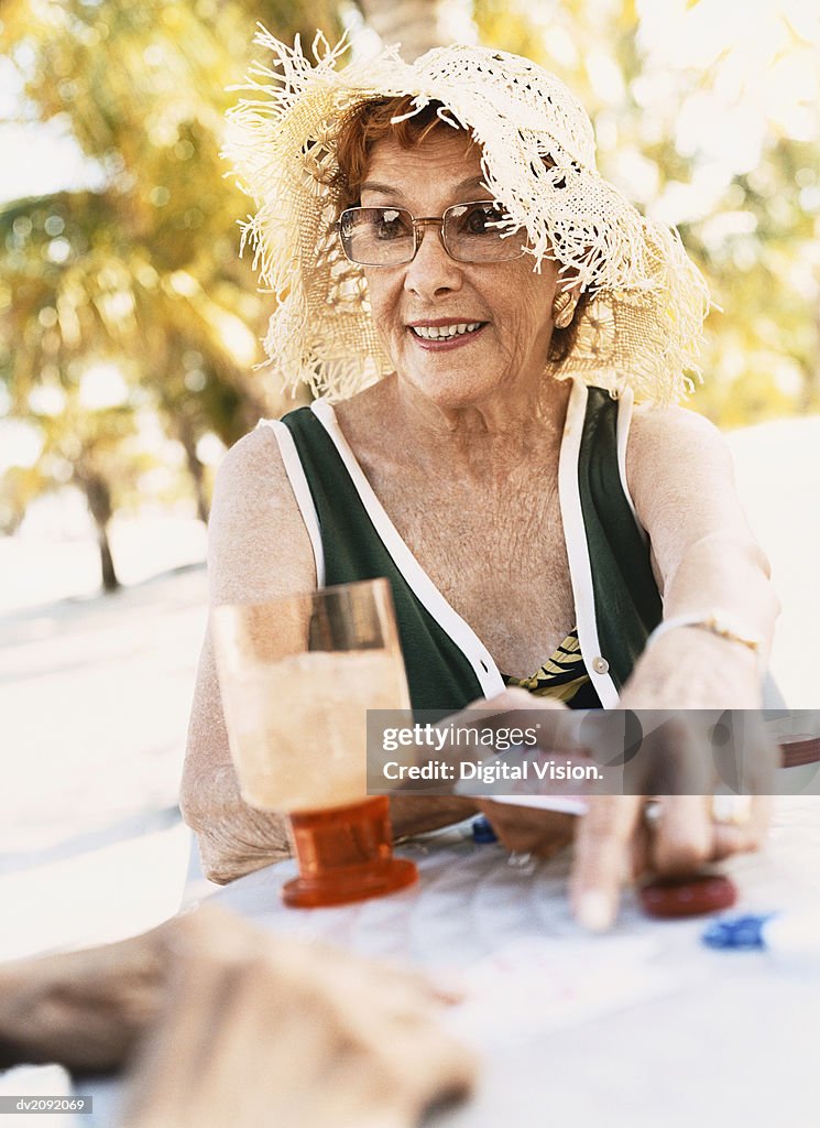 Woman Holding Playing cards and Pointing at a Table