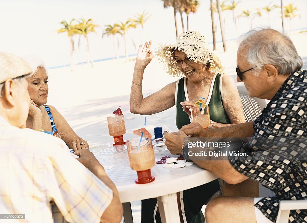 Four Senior People Playing Poker on the Beach