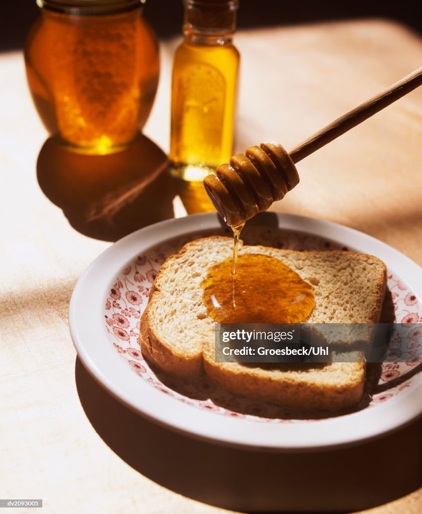 Honey Drizzler Dripping Honey On a Slice of Brown Bread