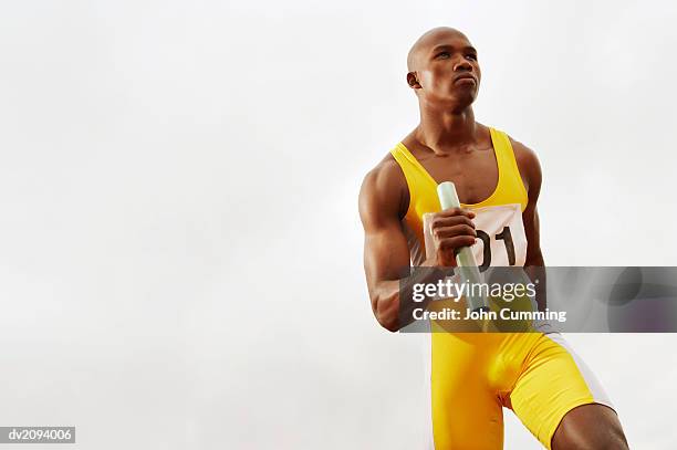 determined looking runner holding a baton - sports competition format stock pictures, royalty-free photos & images