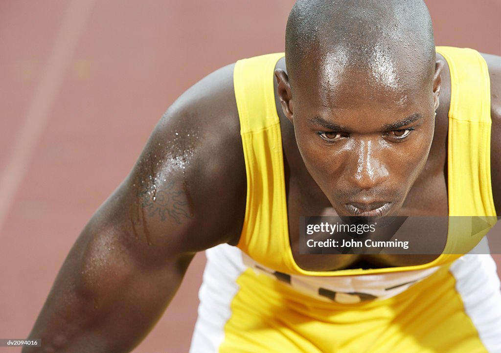 Male Athlete Crouching on Starting Blocks on a Running Track