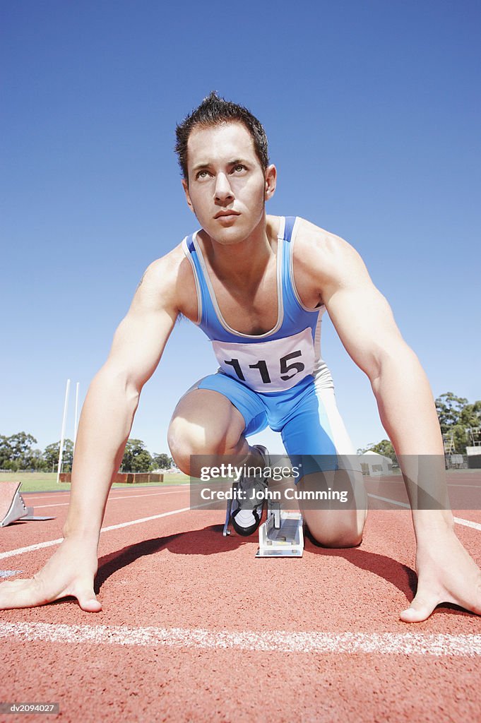 Athlete Crouching on the Starting Blocks of a Running Track