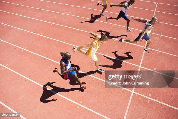 elevated view of a sprinter crossing the finishing line on a running track - finish line stock pictures, royalty-free photos & images