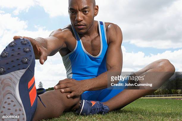 athlete doing stretches - zehenspitzen berühren stock-fotos und bilder