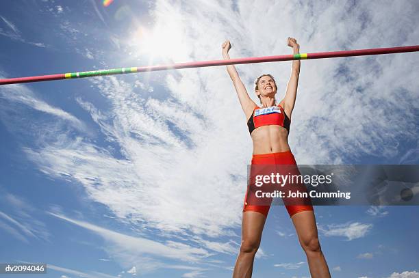 athlete celebrating after doing the high jump - barre-de-saut-à-la-perche photos et images de collection
