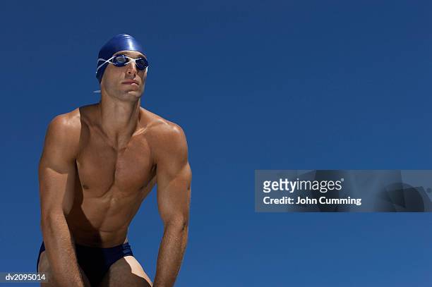 male swimmer with his hands on his knees - standing with hands on knees imagens e fotografias de stock