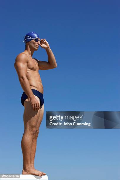 male swimmer adjusting his swimming goggles - young men in speedos 個照片及圖片檔