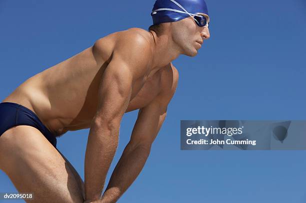 male swimmer with his hands on his knees - young men in speedos stock-fotos und bilder