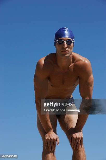 male swimmer with his hands on his knees - young men in speedos bildbanksfoton och bilder
