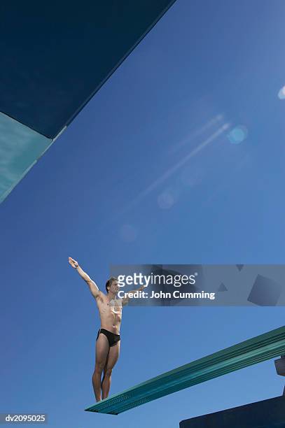 male swimmer at the edge of a diving board - young men in speedos stock pictures, royalty-free photos & images