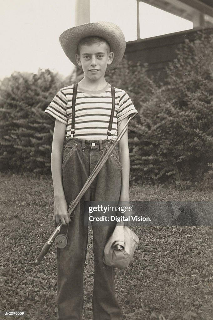 Boy Standing in a Garden Holding a Fishing Rod