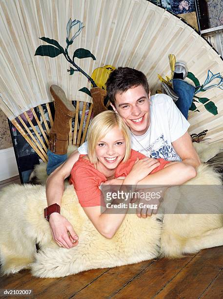portrait of a young couple lying on a fur rug - liz white stock pictures, royalty-free photos & images