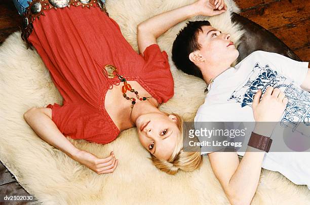 young couple lying on a fur rug - liz white stock pictures, royalty-free photos & images