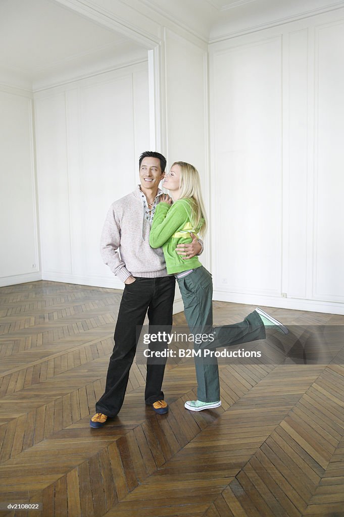 Couple Standing on Wooden Floor in an Empty House
