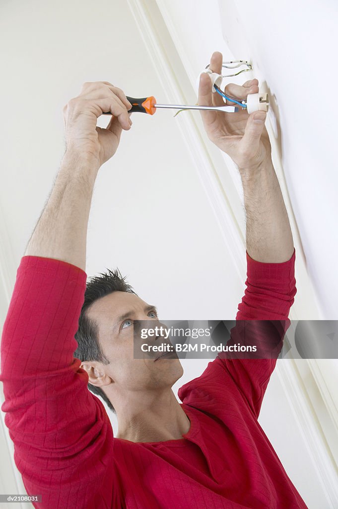 Man Wiring a Socket in a Wall