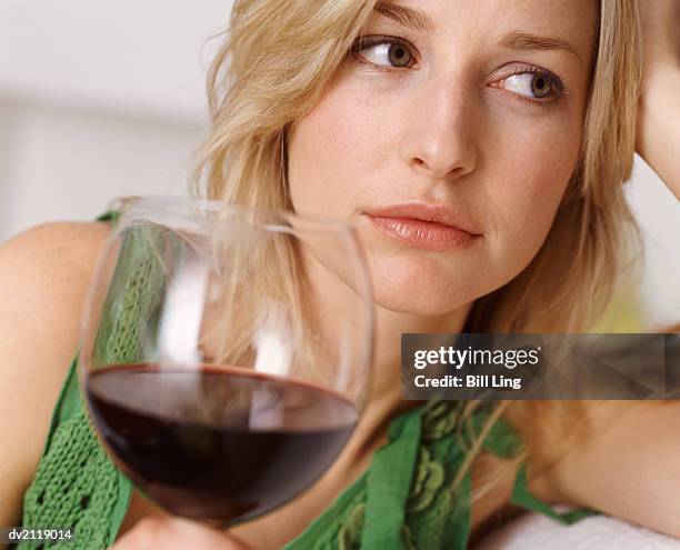 unhappy looking woman holding a glass of red wine - finger waves stock pictures, royalty-free photos & images