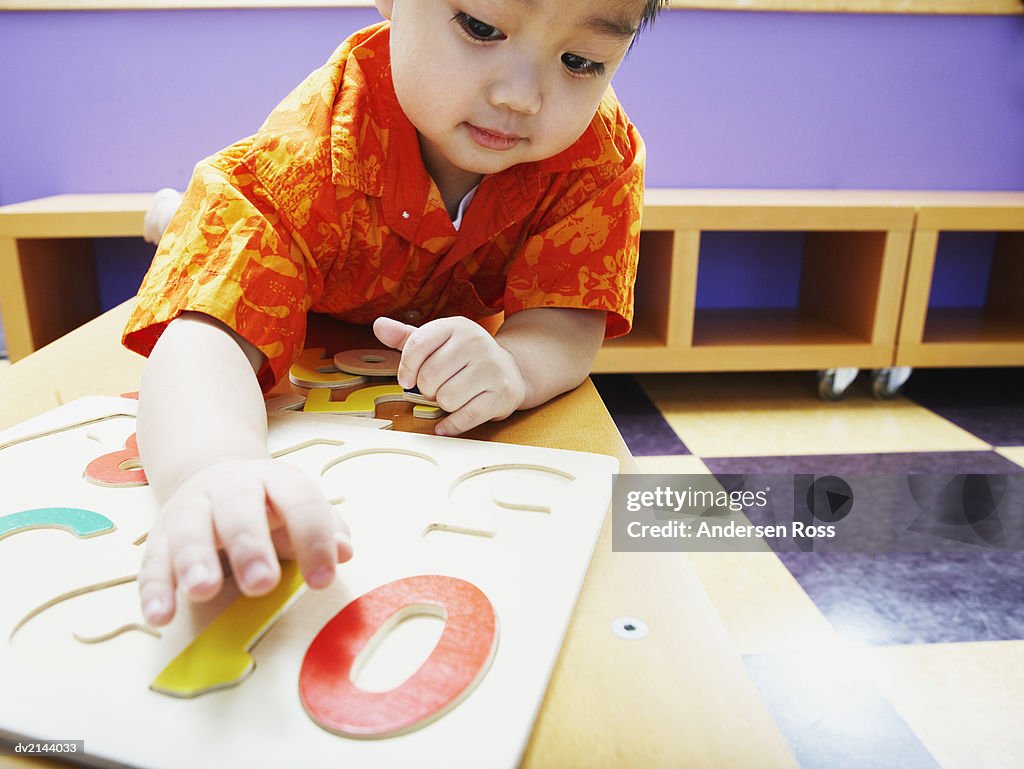 Young Boy Inserting Numbers Into a Board