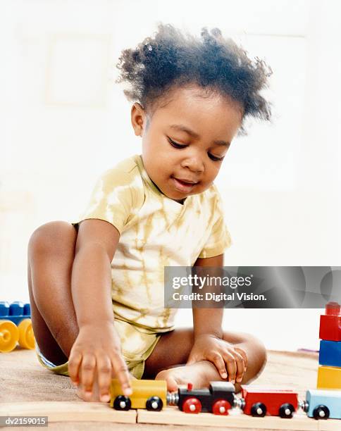 young girl playing with a toy train set - one baby girl only fotografías e imágenes de stock