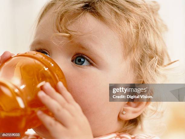 infant girl drinking from a cup - one baby girl only foto e immagini stock