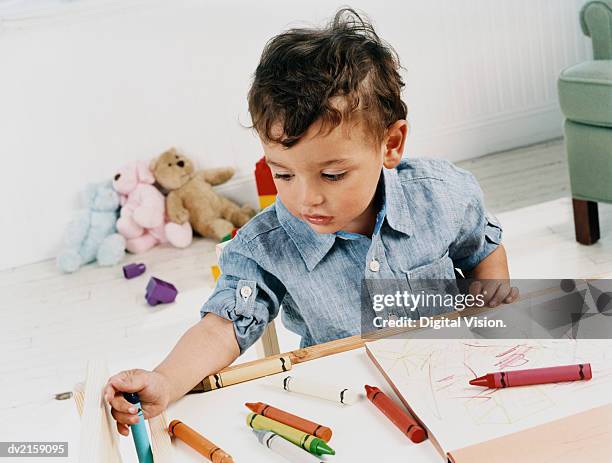 boy toddler sitting colouring with crayons - colouring fotografías e imágenes de stock