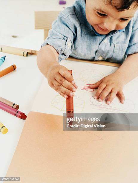 boy toddler sitting colouring with crayons - colouring fotografías e imágenes de stock