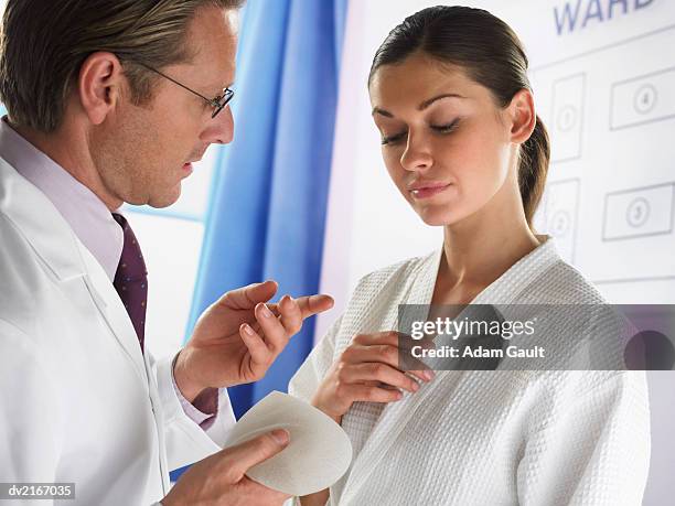 plastic surgeon discussing brest implants with a woman - aumento dos seios imagens e fotografias de stock