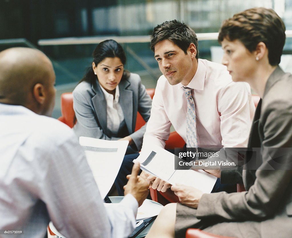 Business People Sitting in an Office Building Having a Meeting