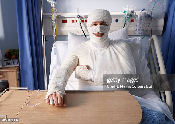 man lying in a hospital bed, covered in bandages - bandage stock pictures, royalty-free photos & images