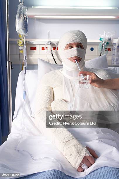 man wrapped in bandages drinking water from a straw - gauze stock pictures, royalty-free photos & images