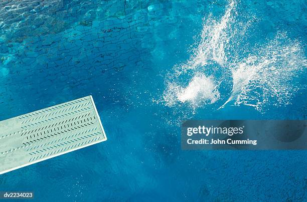 splashing water and a diving board - trampolino piscina foto e immagini stock