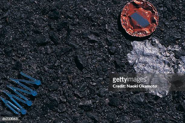 flattened red metal bottle top, silver patch, and broken blue plastic hair accessory on shiny black - black hair texture stock pictures, royalty-free photos & images