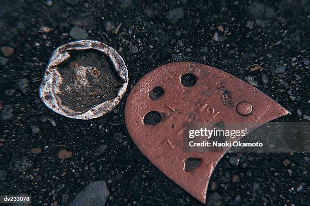 close up of heel portion of sole of shoe and flattened silver bottle top in black asphalt - sole photos et images de collection