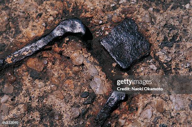 close up of black metal encased in brown conglomerate stone - brown stone stock pictures, royalty-free photos & images