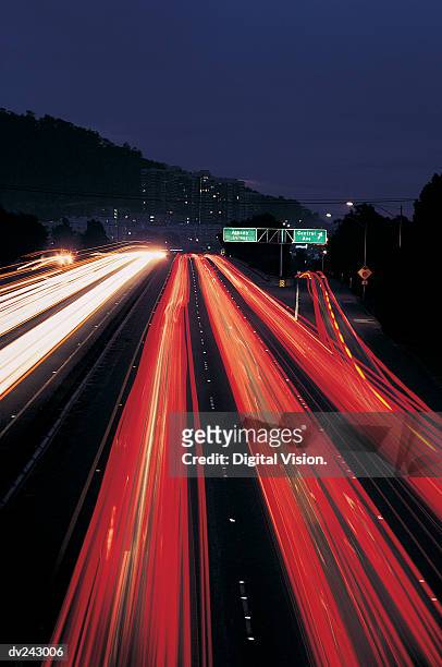 long exposure of traffic, exit ramp on right - vierbaansweg stockfoto's en -beelden