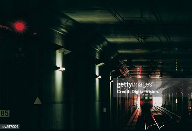 car pulling out of dark tunnel - bahntunnel stock-fotos und bilder