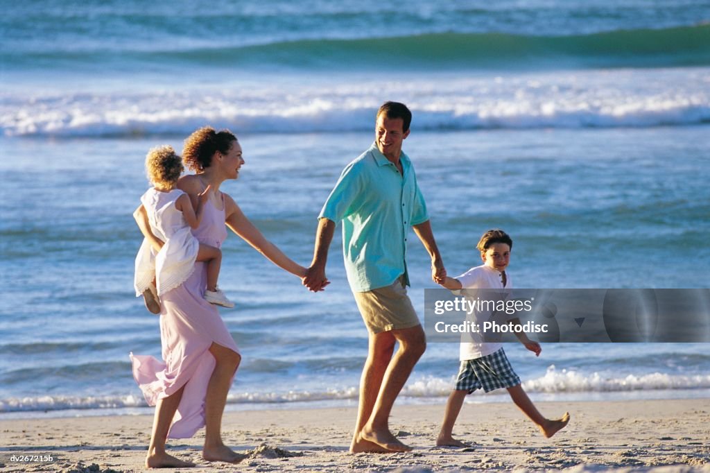 Parents walking on beach with children