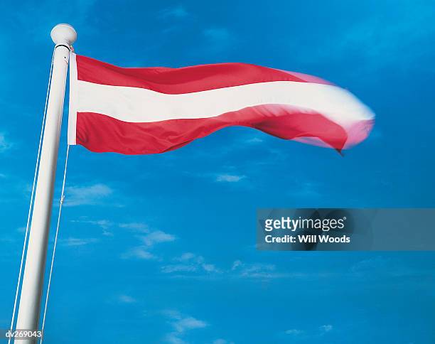 flag of austria on flagpole waving in wind - austria flag stock-fotos und bilder