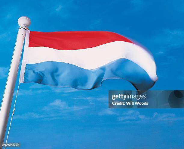 flag of luxembourg on flagpole waving in wind - luxembourg flag stock pictures, royalty-free photos & images