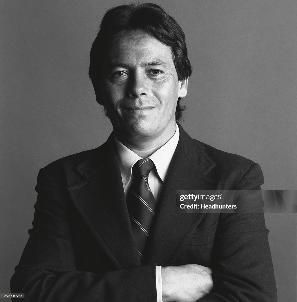 Confident businessman in suit with arms folded